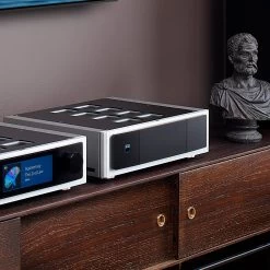 NAD Masters Series M23 HybridDigital Stereo Power Amplifier -Audio Bliss Boutique NADM23M33onWoodCabinetwithDaliTowersCloseSide Facebook 2048x2048 1